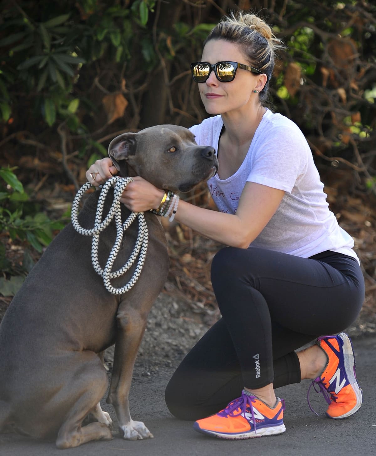 Sophia Bush wears orange and purple New Balance 1500v1 sneakers with Reebok One Series tights and Lokai classic and limited edition bracelets while out with her dog Griffin