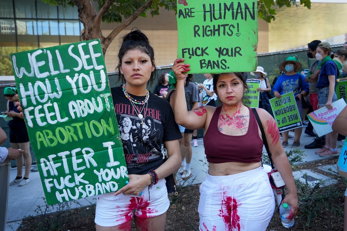 An abortion protester in Los Angeles holds a placard saying "We'll see how you feel about abortion after I fuck your husband"