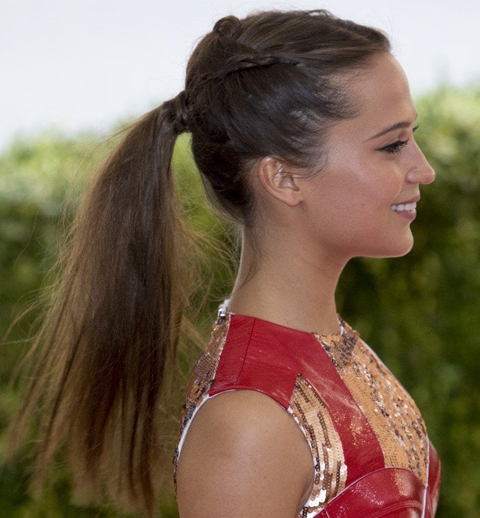 Alicia Vikander styles her hair back in a ponytail at the 2016 Met Gala