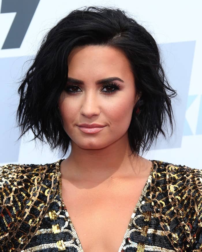 Demi Lovato rocks a bold look with her tousled black hair and flawless makeup