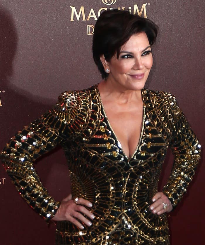 Kris Jenner exudes confidence in her black and gold Balmain sequin dress, highlighting her flawless skin and radiant smile at the Magnum Double party during the Cannes Film Festival