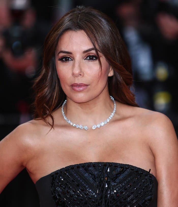 The upper portion of Eva Longoria's dress, reminiscent of a corset-style design, featured a gracefully curved neckline that modestly obscured her generous cleavage, hinting at its presence while retaining an air of sophistication