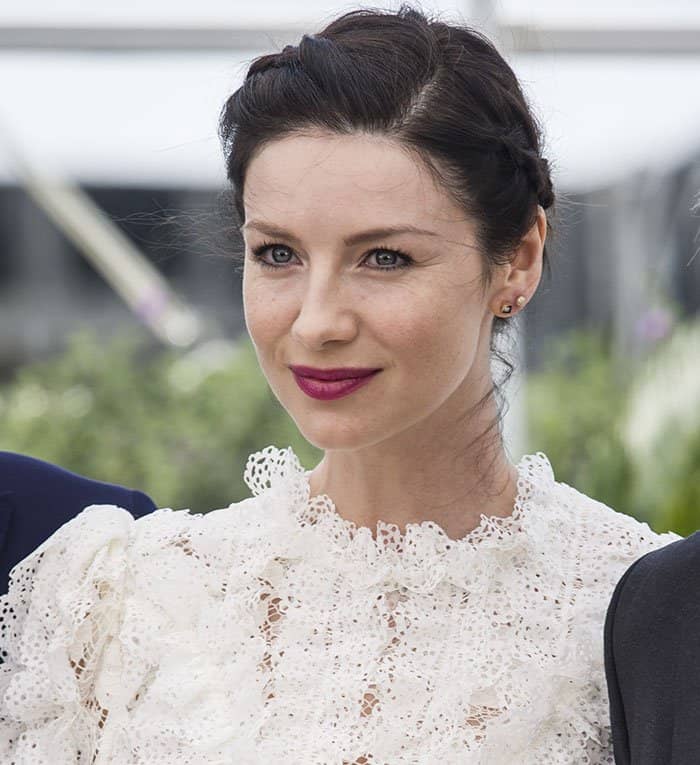 Caitriona Balfe showcases her elegant braided updo, bold plum lips, and striking blue eyes