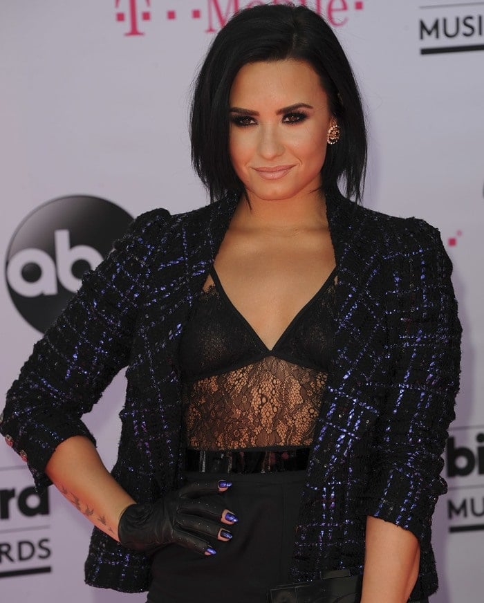 Demi Lovato flaunts her toned stomach in a black lace bodysuit by House of CB