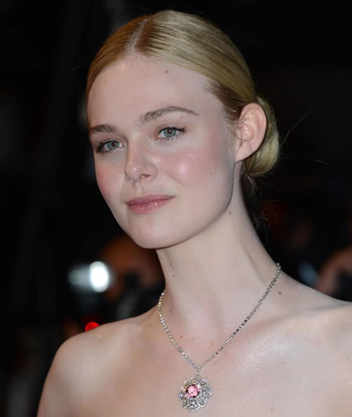 Elle Fanning wore a pink lip and a sleek center-parted chignon to complement her appearance