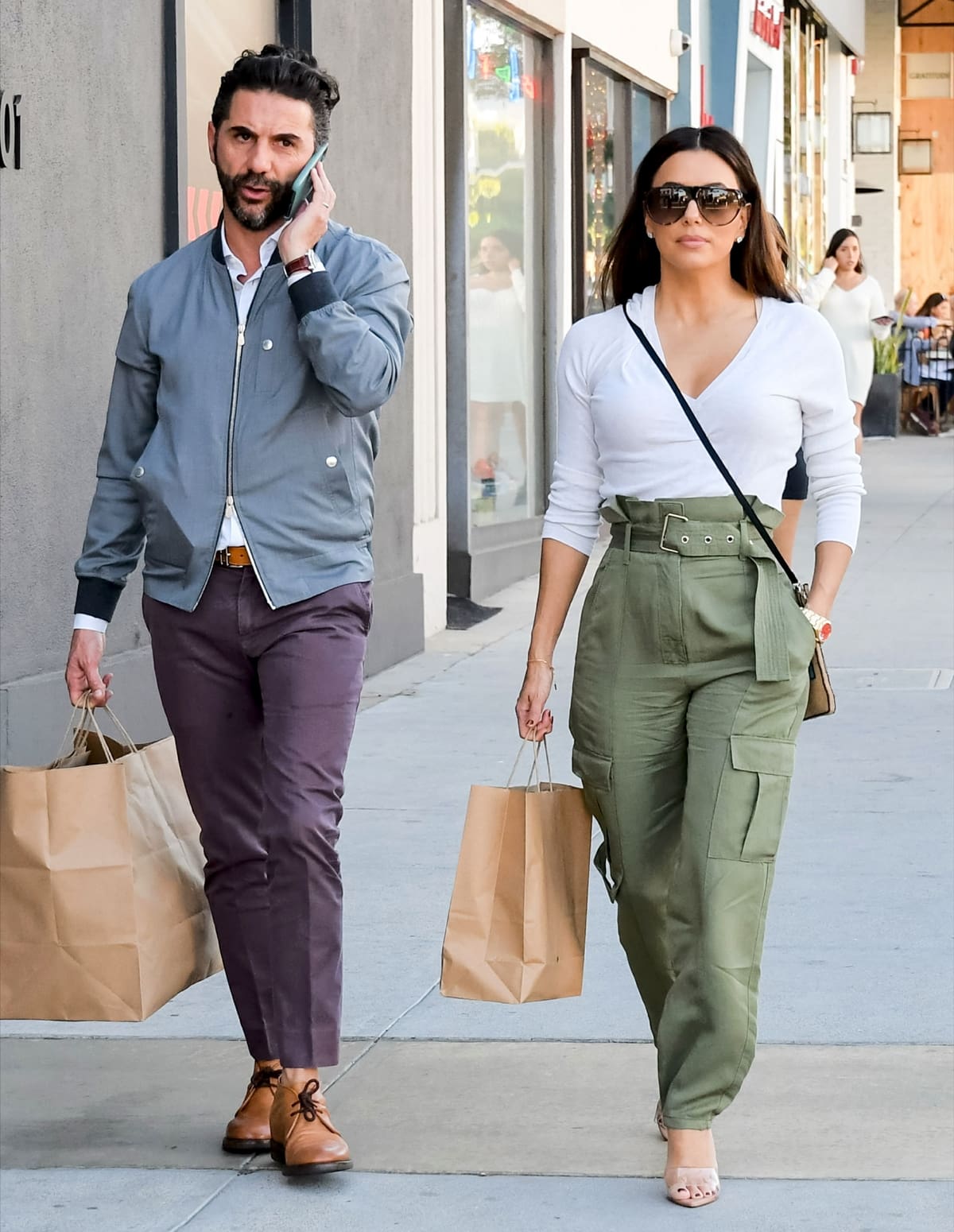 Eva Longoria, wearing Rag & Bone Tilda cargo pants paired with a white blouse, Gianvito Rossi Lyn mules, and a Sabukana Loteria bag, and her husband José Bastón enjoy an afternoon of shopping