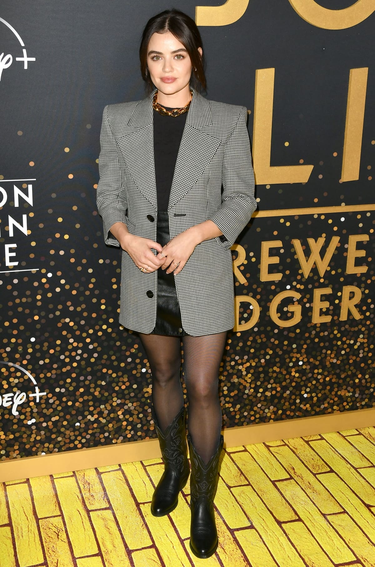 Lucy Hale wears stockings with black Ariat Heritage R Toe Western boots at the Disney+ "Elton John Live: Farewell From Dodger Stadium" Yellow Brick Road Event