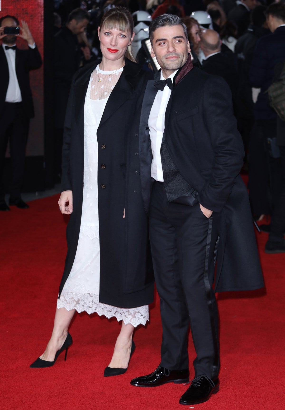 Óscar Isaac and his wife, Elvira Lind, made a stylish appearance at the European premiere of Star Wars: The Last Jedi at Royal Albert Hall on December 12, 2017, in London, with Lind in a chic white lace dress paired with black pointed-toe pumps and Isaac looking sharp in a classic tuxedo and polished black dress shoes