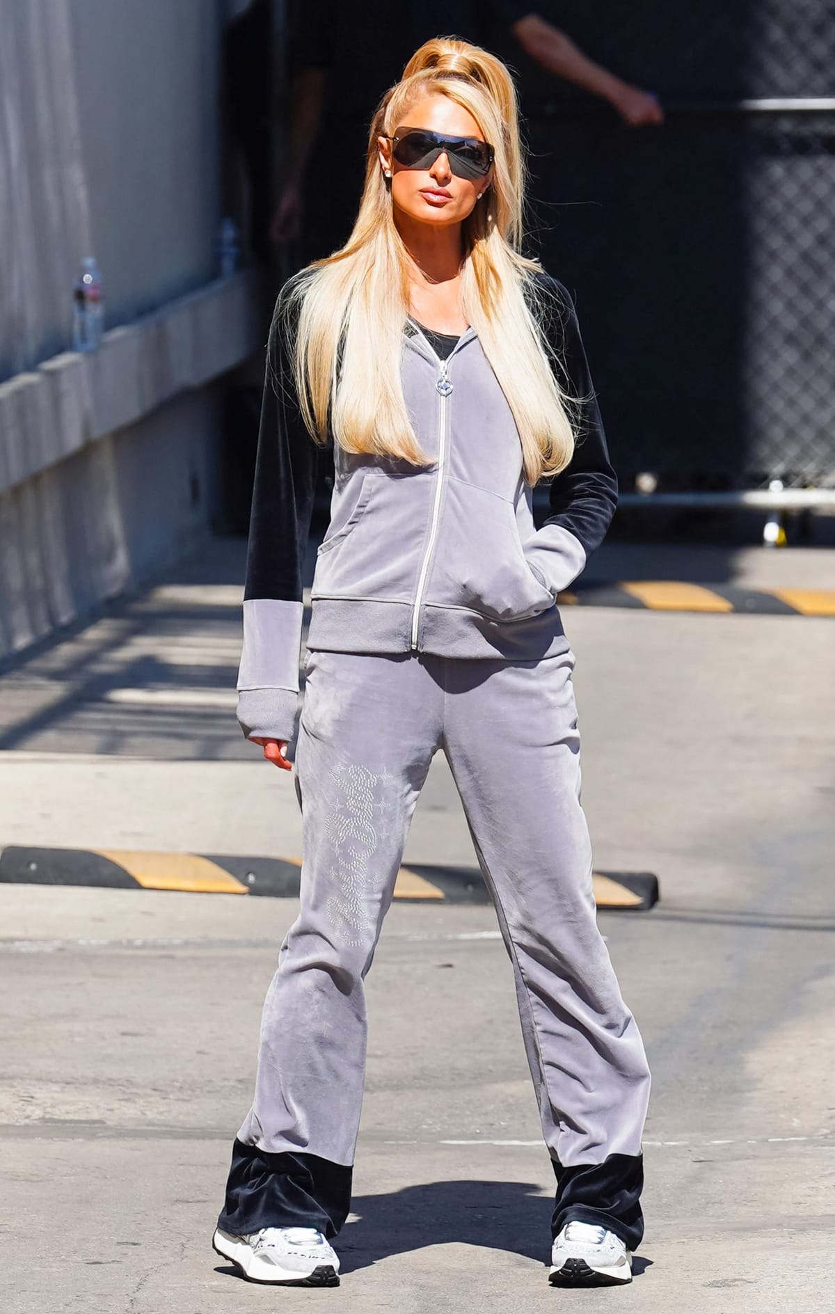 Paris Hilton in a gray velour tracksuit from her own collection outside "Jimmy Kimmel Live"