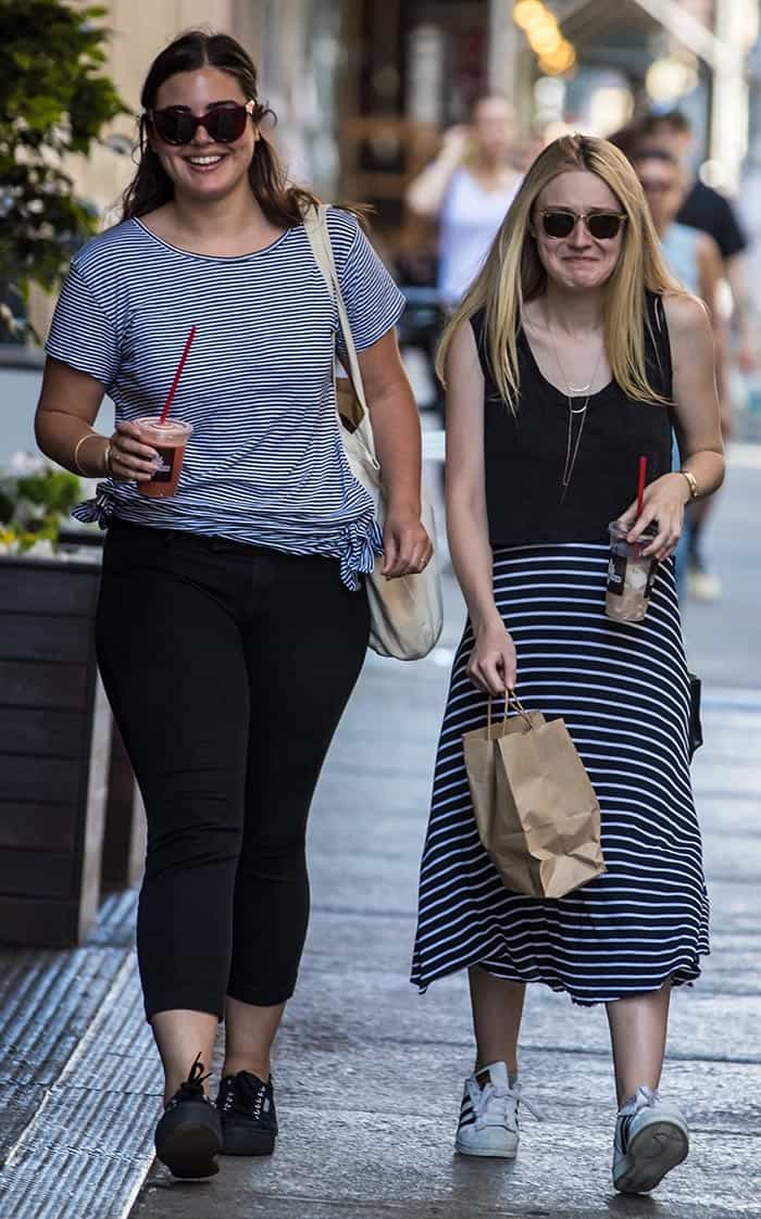 Dakota Fanning and her friend coordinate in stripes while enjoying iced coffee in SoHo