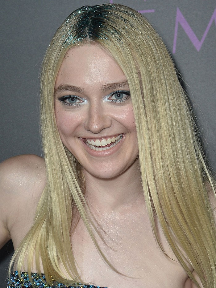 Dakota Fanning sparkles with glitter in her hair and a shimmery blue eyeshadow, perfectly complementing her sequined dress at The Neon Demon premiere