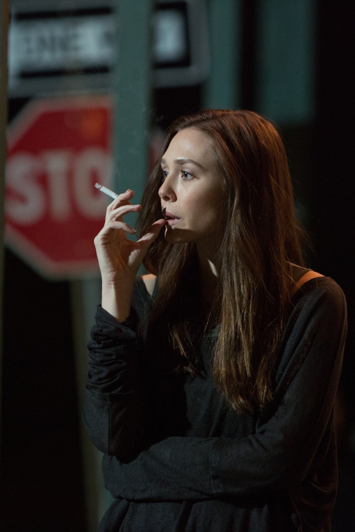 Elizabeth Olsen smokes a cigarette as Marie Sebastian in Spike Lee's 2013 American neo-noir action thriller film Oldboy