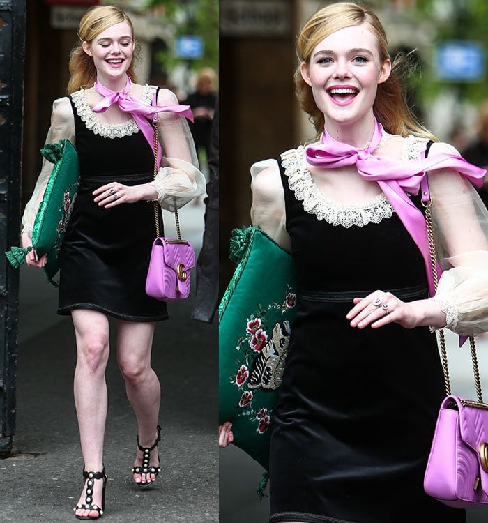 Elle Fanning smiles in a velvet Gucci Victorian-style dress with bright fuchsia accents