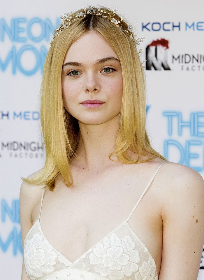 Elle Fanning wears a floral crown over her hair at the photo call for "The Neon Demon"