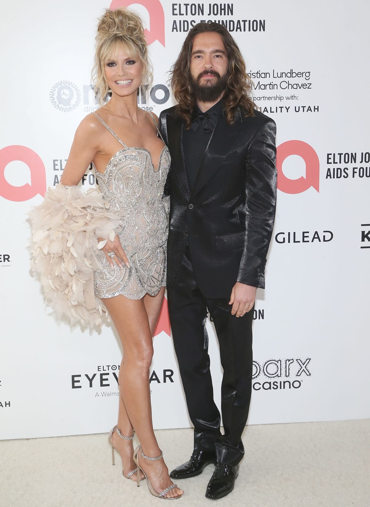 Heidi Klum in an Elie Saab mini dress and her husband Tom Kaulitz arrive at the Elton John AIDS Foundation's 30th Annual Academy Awards Viewing Party