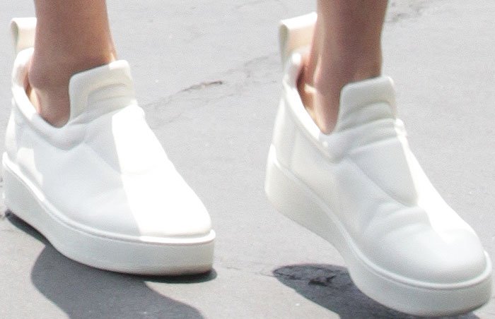 Gigi Hadid's feet in bright white Céline slip-ons