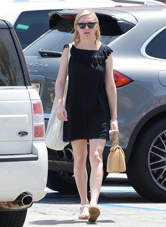 Kirsten Dunst keeps it casual with damp hair, a black mini dress, and white Chanel wedge sandals while running errands in Los Angeles