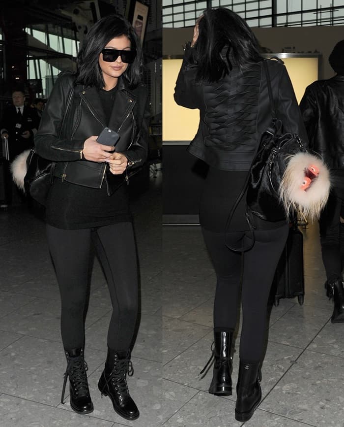 Kylie Jenner turns heads at Heathrow Airport on March 15, 2015, in a sleek all-black ensemble featuring lace-up heeled combat boots, a House of CB biker jacket, and her edgy Elizabeth and James crocodile backpack topped with a playful Fendi Fur Bag Bug