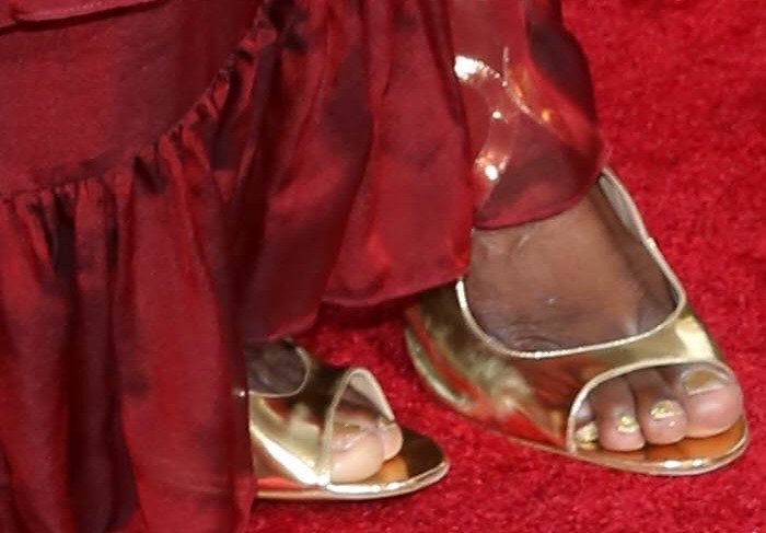 Laverne Cox showing off her feet in metallic Lonia sandals