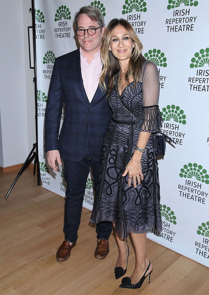 Matthew Broderick exudes sophistication in a checked navy suit, while Sarah Jessica Parker dazzles in a sheer Temperley London midi dress paired with sparkling slingback pumps