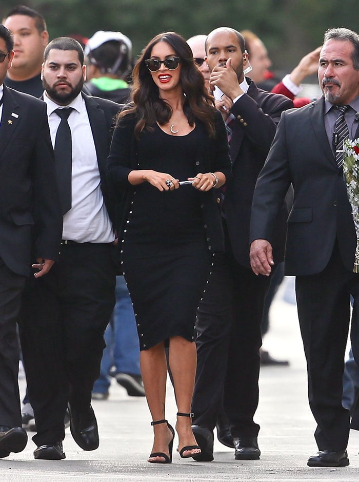Megan Fox flaunted her baby bump in a chic black Alexander Wang dress paired with strappy black heels and a black cardigan