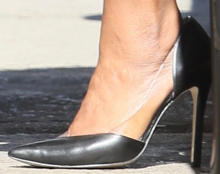 Mindy Kaling jumps out of her car in a pair of asymmetrical PVC leather pumps