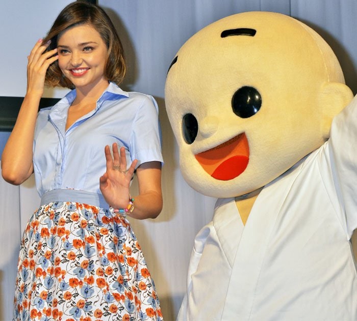 Miranda Kerr poses with the mascot after putting on a simple cooking demonstration for the press