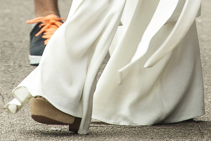 Light brown suede platform sandals with peep toes and chunky heels peeking out from underneath Nicole Scherzinger's white palazzo pants