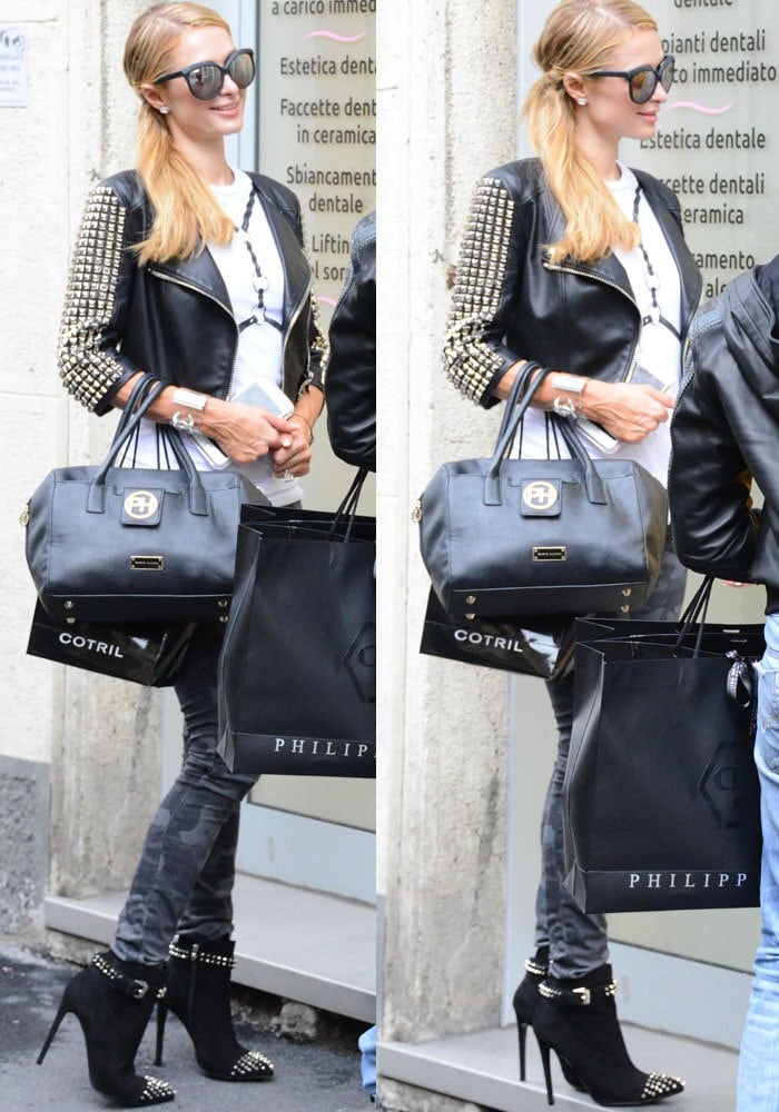 Paris Hilton steps out in Milan wearing a studded Philipp Plein leather jacket, camouflage skinny jeans, and matching black studded booties, accessorized with a sleek black handbag from her own collection