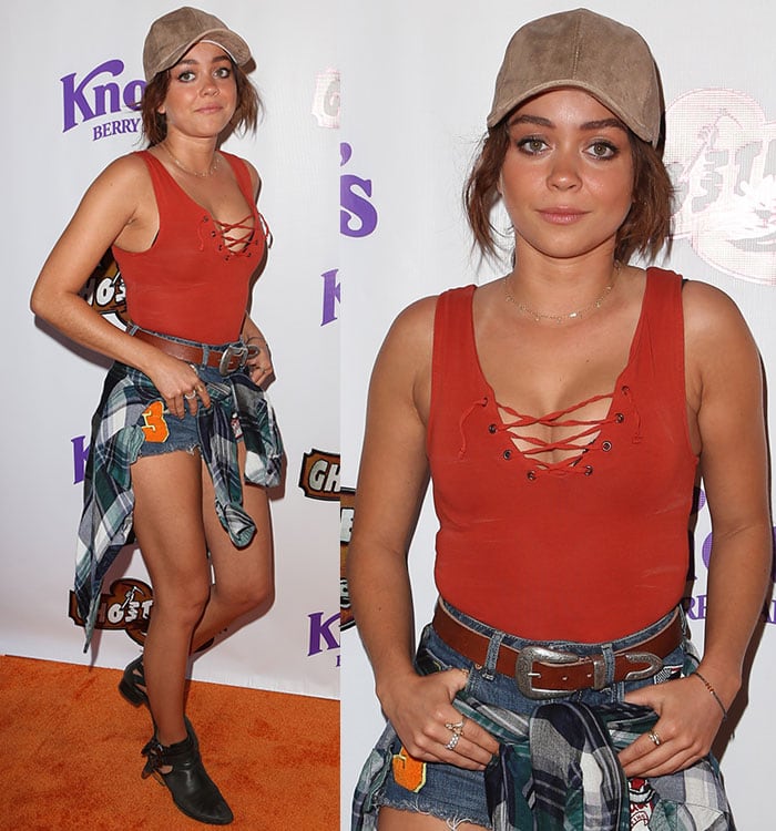 Sarah Hyland wraps a flannel shirt around her waist on the orange carpet