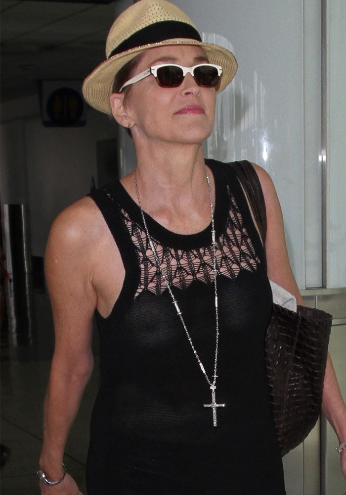 Sharon Stone tops her short hair with a hat as she arrives at Los Angeles International Airport