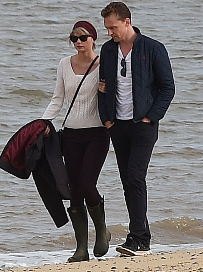 Taylor Swift clings on to her new man as they take a romantic stroll along the beach