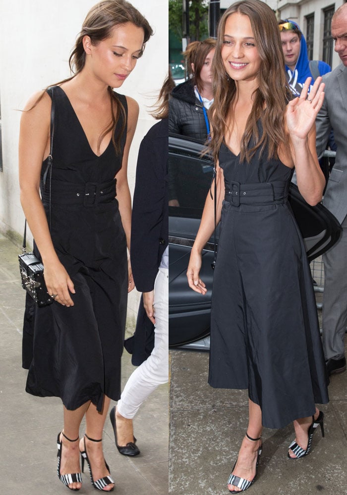 Alicia Vikander wears a plunging black dress to a radio appearance in London