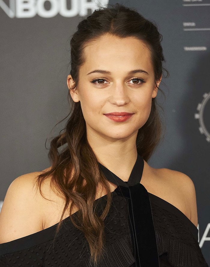 Alicia Vikander sweeps her hair back at a photo call for "Jason Bourne"