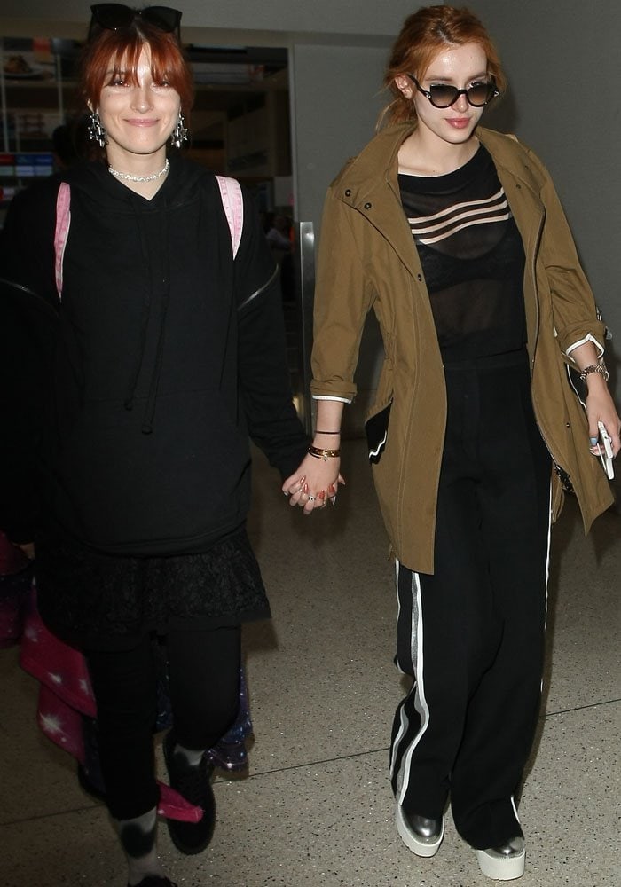 Dani Thorne and Bella Thorne hold hands as they depart for Paris from Los Angeles