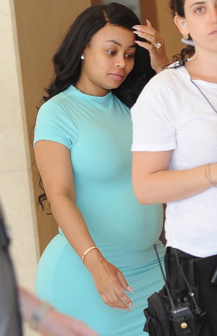 Blac Chyna keeps her look effortlessly natural, with minimal makeup and soft, flowing waves, letting her vibrant aqua dress and curvy silhouette do all the talking