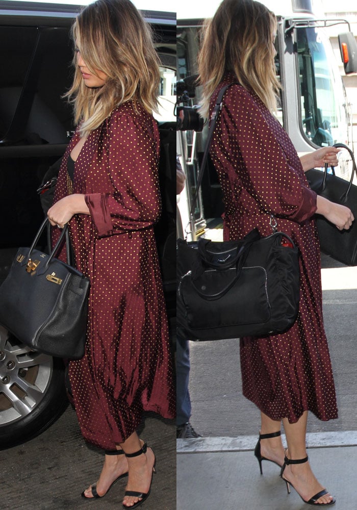 Chrissy Teigen exudes effortless style at LAX in a burgundy polka-dot robe over a black midi dress, paired with classic Gianvito Rossi 'Portofino' sandals and her signature Hermès 'Birkin' bag