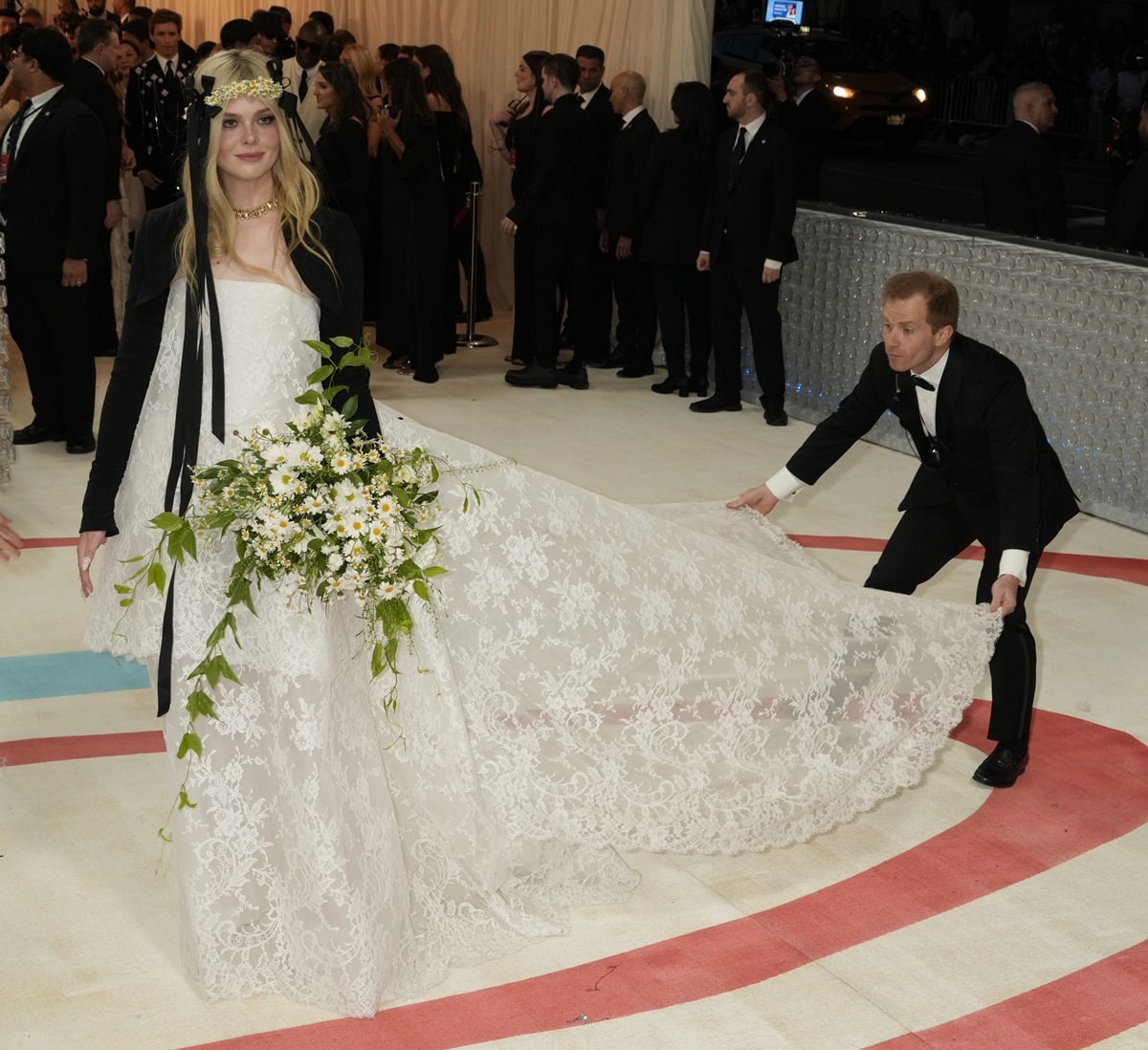 Elle Fanning opted for a woodland-inspired take on the Chanel bride, donning a gorgeous lace gown by Vivienne Westwood, accompanied by a black bolero jacket, at the 2023 Costume Institute Benefit celebrating “Karl Lagerfeld: A Line of Beauty” at the Metropolitan Museum of Art