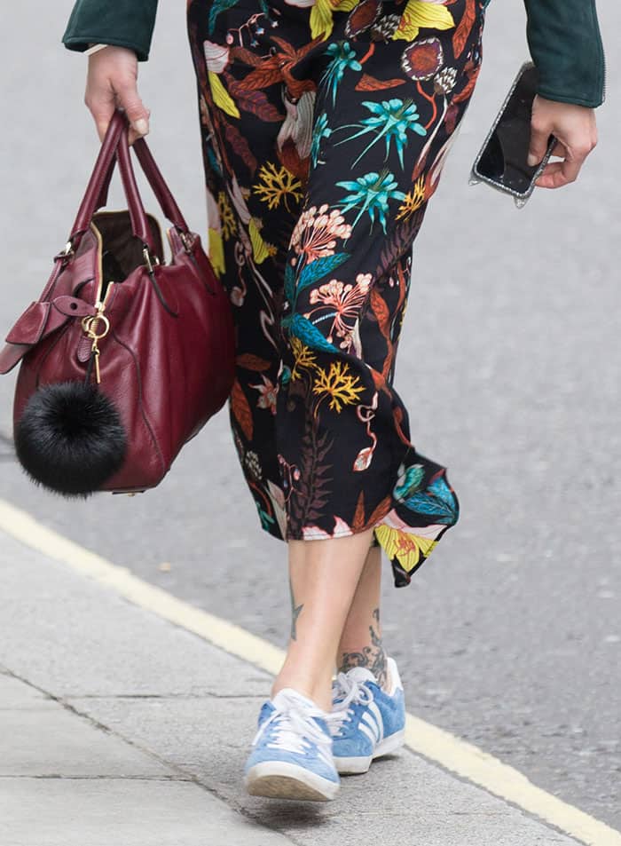 Remaining faithful to a darker color palette, Fearne Cottonadeptly harmonized her ensemble with a chic maroon handbag, accentuating her innate style flair