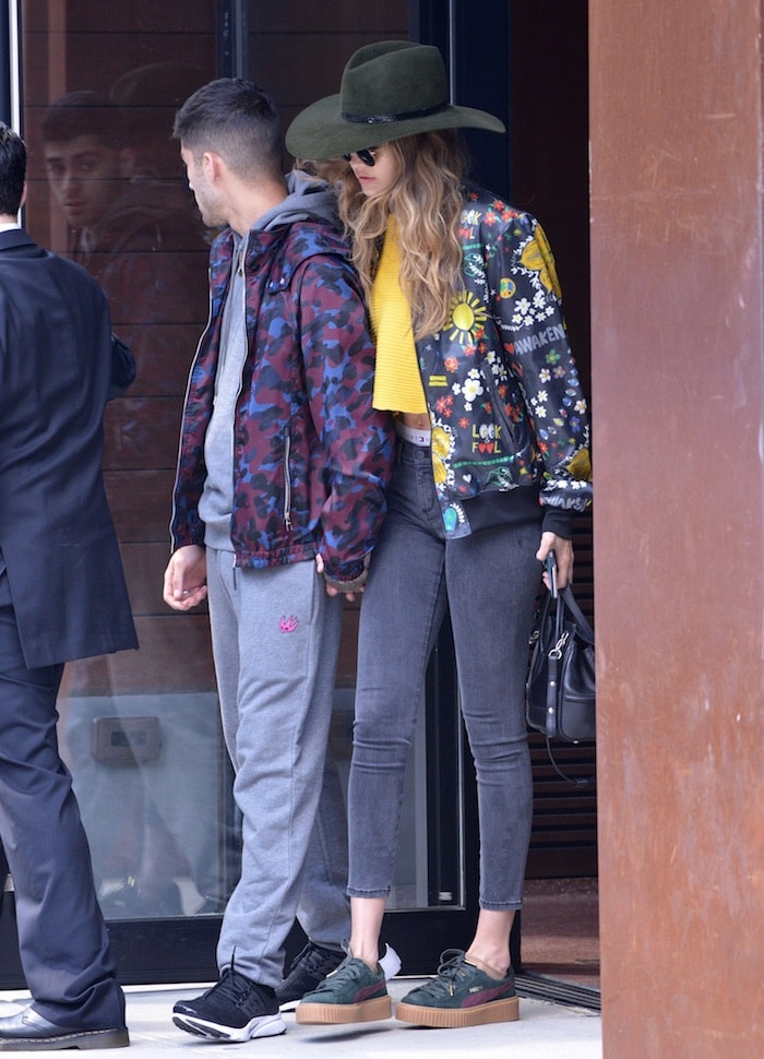 Gigi Hadid wears a colorful printed blouson jacket from the Adidas Originals x Pharrell Williams collaboration with skinny jeans and creepers while leaving her New York City apartment with Zayn Malik