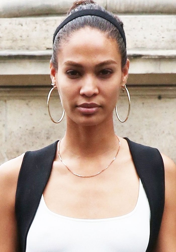 Joan Smalls with statement oversized hoop earrings and effortless hair styled in a messy bun for the Atelier Versace show