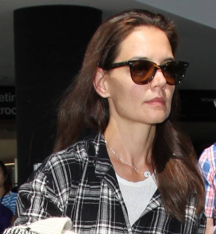 Katie styled her glossy brunette hair in a simple, straight-down look and accessorized with tortoiseshell sunglasses and a delicate silver necklace