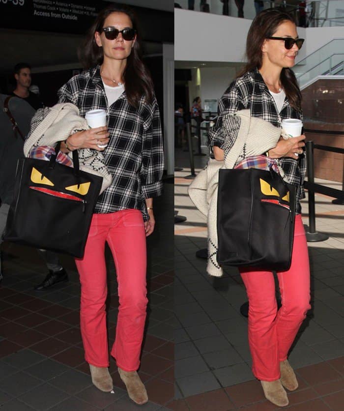 Katie Holmes keeps it effortlessly stylish at LAX on June 30, 2016, pairing a black-and-white plaid shirt with bold red jeans, suede ankle boots, and the playful Fendi Monster Creature Tote for a chic yet relaxed travel look