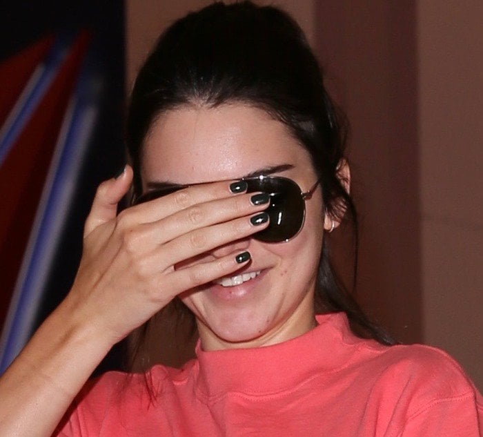 Kendall Jenner, with visible blemishes, tries to keep her face covered as she arrives at LAX on July 25, 2016