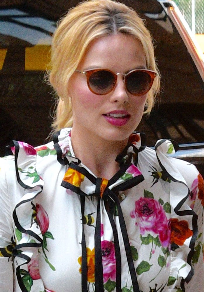 Margot Robbie clips her hair back as she returns to her Manhattan hotel