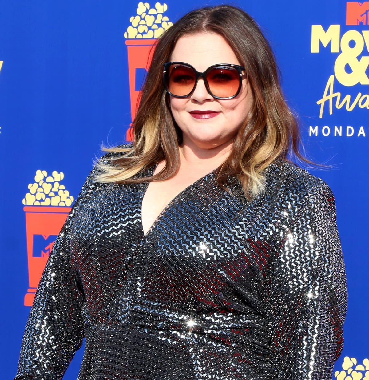 Melissa McCarthy rocks sunglasses with Dena Kemp jewelry and a sequined jumpsuit by Talbot Runhof