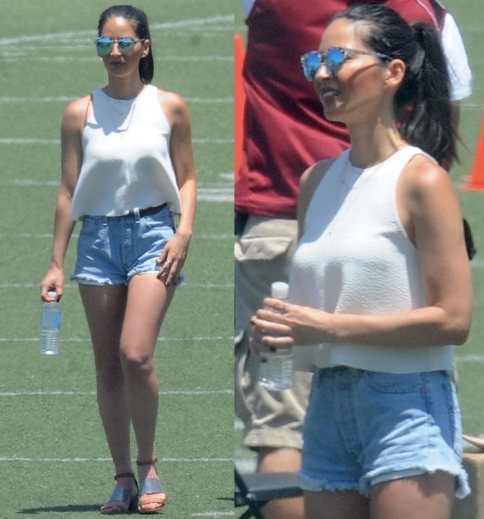 Olivia Munn wears a white tank top with short denim shorts out in Los Angeles