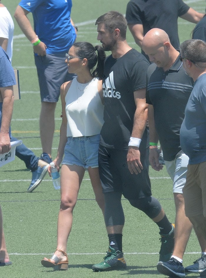 Olivia Munn visits with Aaron Rogers during a commercial shoot in Los Angeles