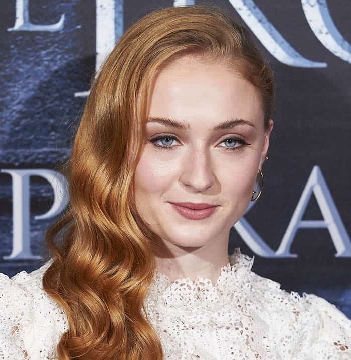 Sophie Turner exudes elegance with her flowing waves and natural makeup look at a "Game of Thrones" fan event