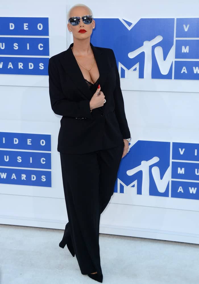 Amber Rose flaunts her cleavage in a La Perla bra paired with a Tom Ford suit
